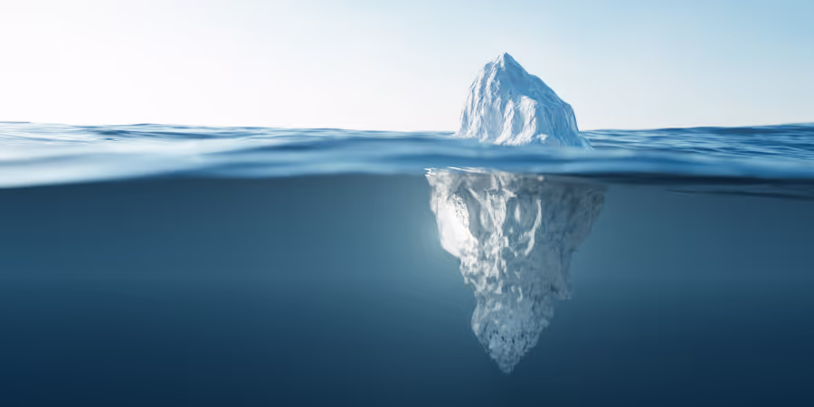 An iceberg visible at water line, both above and below.